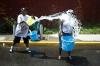 Люди обливают друг друга водой из гидранта в районе Бруклина в Нью-Йорке.