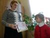Елена Гришко держит картинку, которая помогает первокласснице Алине Луговской рассказывать стихотворение.