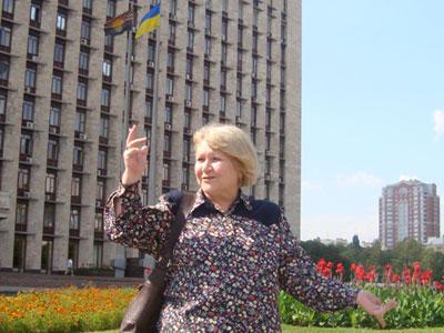 Нина Щербак у здания областной госадминистрации, возле которого рядом с национальным реет ее детище - областной флаг.